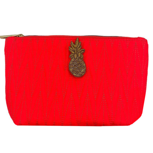 Orange Tribeca make up bag with a pineapple pin