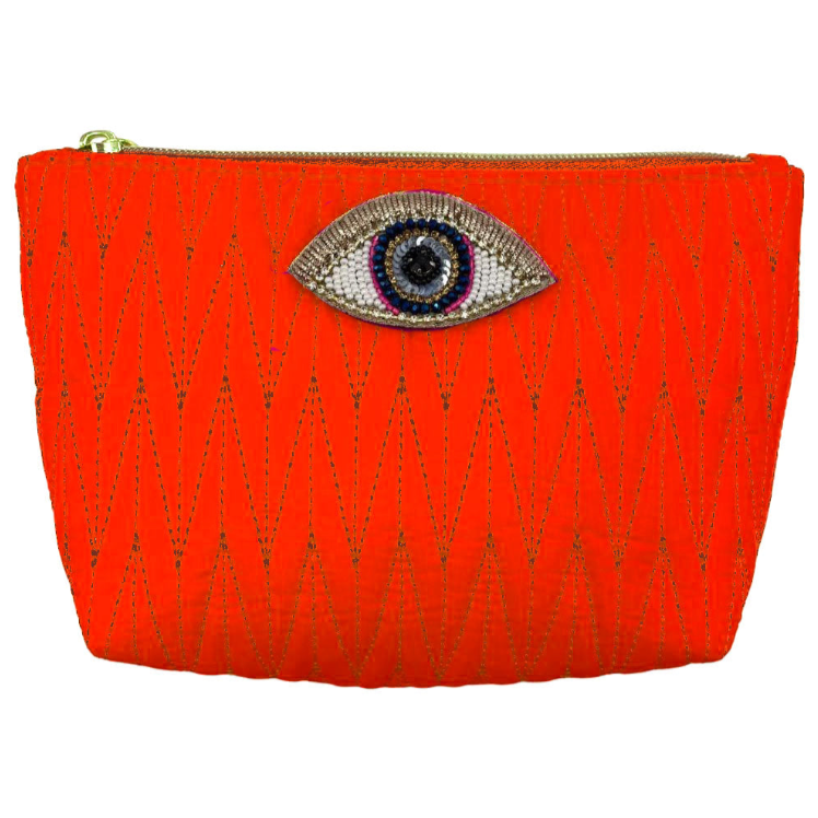 Orange Tribeca make up bag with a golden eye pin
